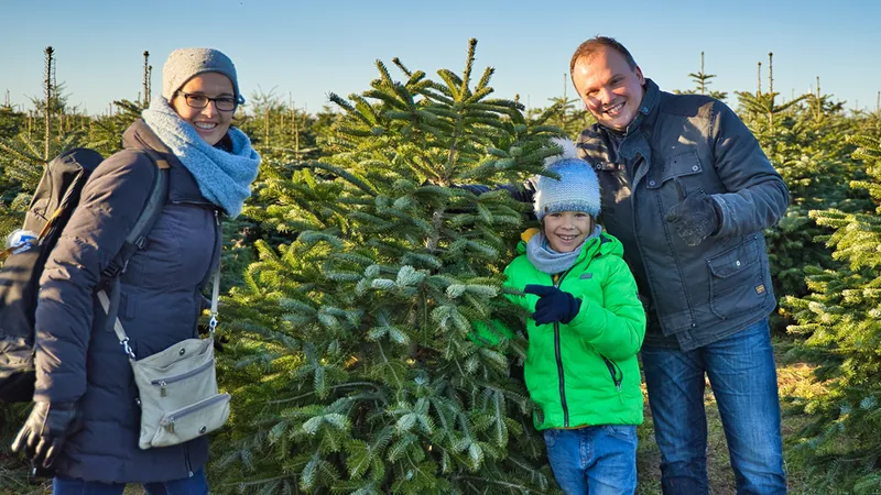 Familie mit ihrem ausgesuchten Weihnachtsbaum